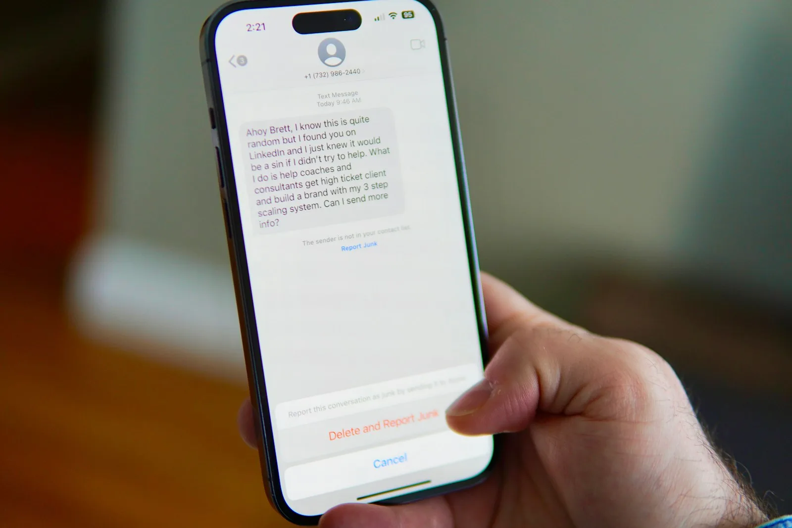 Main tenant un smartphone affichant un SMS