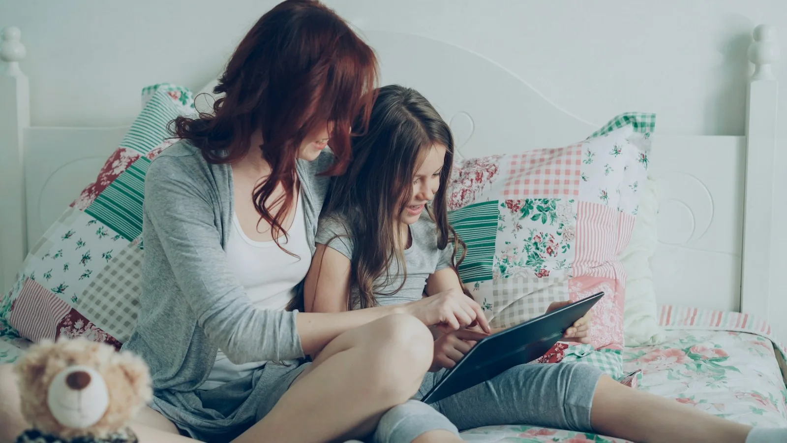 Une mère et sa fille regardent ensemble une tablette
