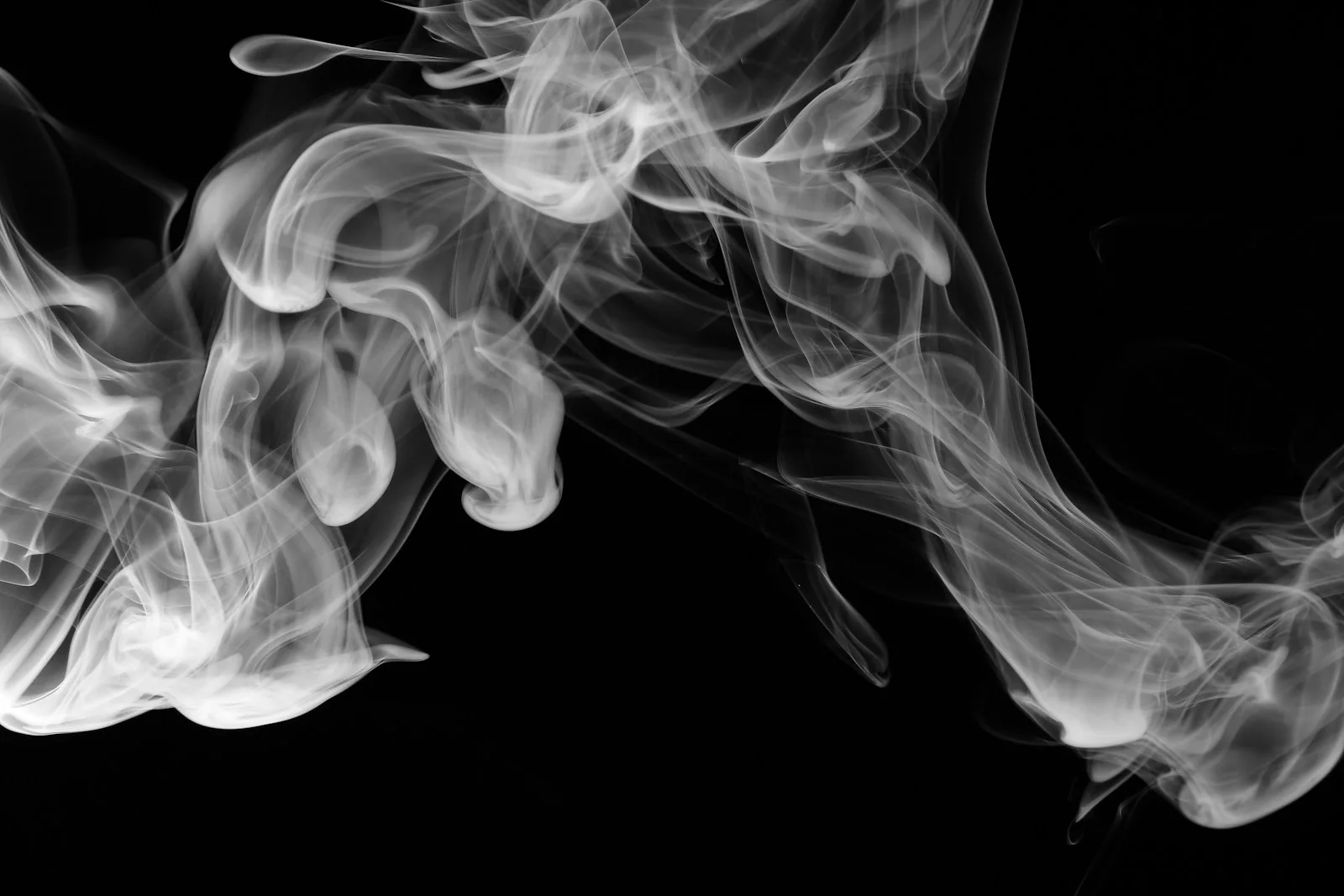 Volutes de fumée blanche sur fond noir