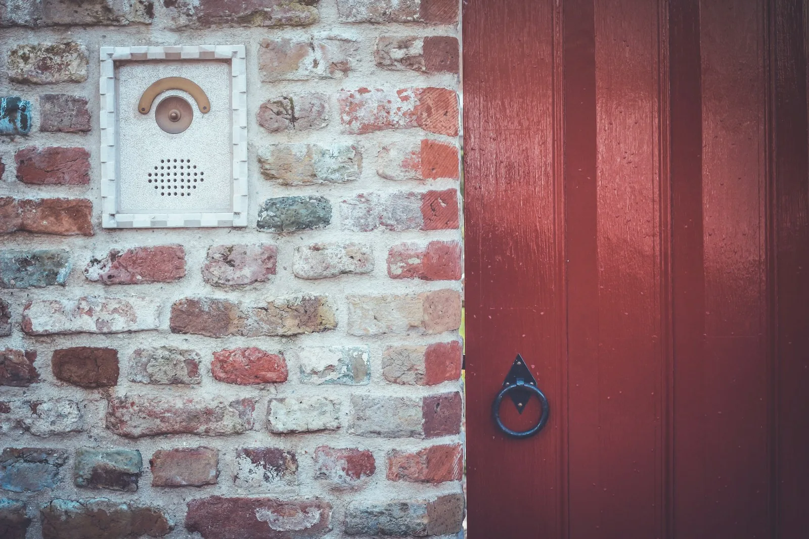 Platine d’interphone sur un mur de briques près d’une porte